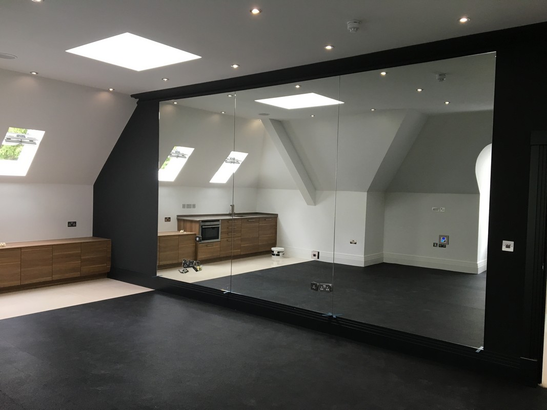 Frameless glass wall dividing loft conversion in Brent Cross